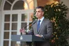 El presidente del Gobierno, Pedro Sánchez en el exterior del Palacio de la Moncloa, vistiendo traje gris y corbata azul, mientras habla desde el atril institucional.