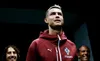 Fotografía de primer plano de Cristiano Ronaldo mirando hacia arriba con gesto serio, luciendo la sudadera roja y azul de la Selección de Portugal con el escudo de la federación lusa.
