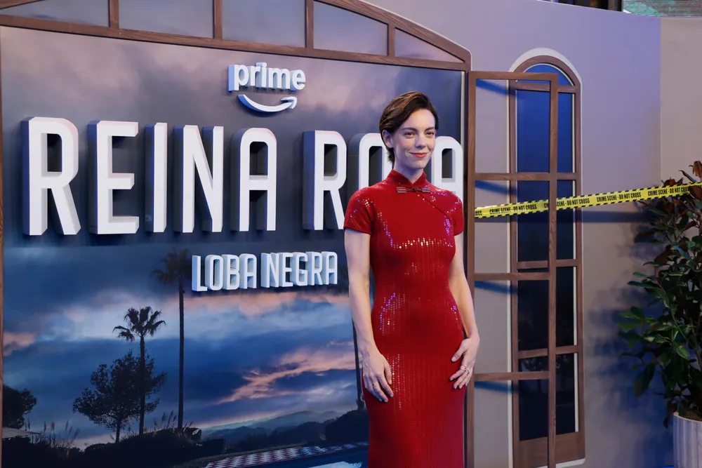 La actriz Vicky Luengo posando sonriente de frente con un vestido ceñido de lentejuelas rojas y cuello alto estilo mandarín. De fondo se lee el cartel en relieve 'prime REINA ROJA LOBA NEGRA'
