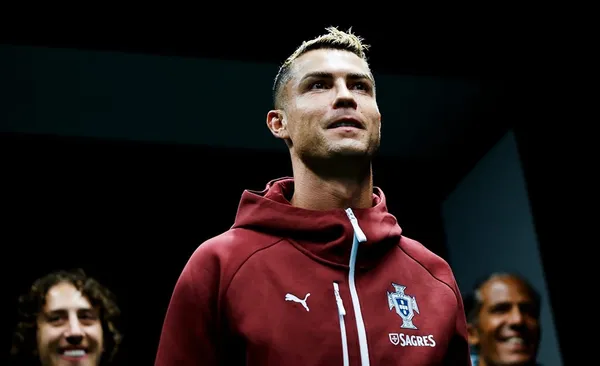 Fotografía de primer plano de Cristiano Ronaldo mirando hacia arriba con gesto serio, luciendo la sudadera roja y azul de la Selección de Portugal con el escudo de la federación lusa.