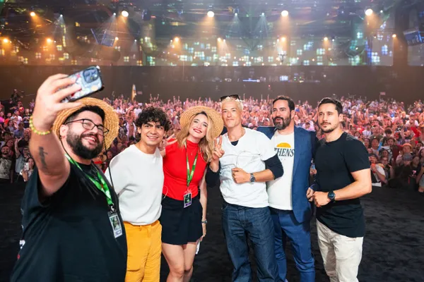 Fotografía desde el escenario de San Diego Comic-Con Málaga donde Capi Joseppe sostiene un teléfono móvil para tomar un selfie junto a Iñaki Godoy, Taz Skylar, Lukas Ettlin y Peter Gadiot.